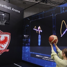 In Tokio stellte Fujitsu auf der Ceatec International im Oktober eine KI-Technologie vor, die beim Basketball Würfe analysiert und vergleicht. Zu sehen ist eine Frau, die vor Videoleinwänden auf einen Korb wirft.  