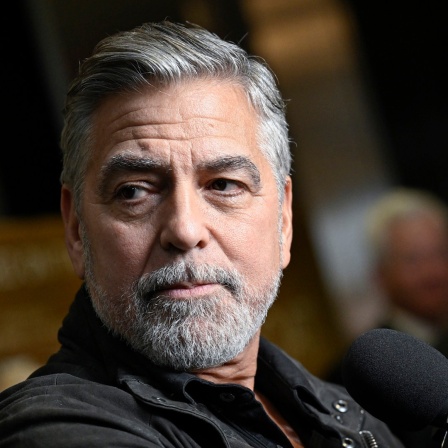 Der US-Schauspieler George Clooney schaut bei einerm Pressetermin zum Film "The Boys in the Boat" im Dezember 2023 an der Kamera vorbei