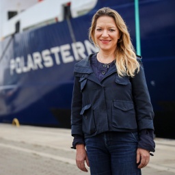 Antje Boetius posiert vor dem Forschungsschiff Polarstern, das am Gelände der Lloyd Werft im Kaiserhafen Drei in Bremerhaven liegt.