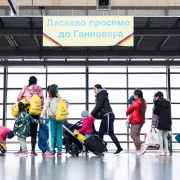 Geflüchtete aus der Ukraine laufen nach ihrer Ankunft durch die Eingangshalle vom Messebahnhof Laatzen.