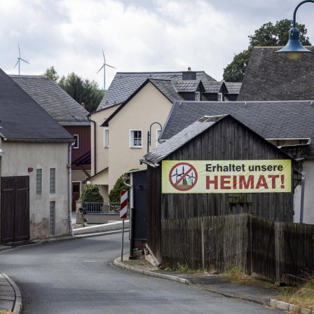 In einem Dorf im ehemaligen Deutsch-Deutschen Grenzgebiet zwischen Thüringen und Bayern hängt ein Protestplakat gegen Windkraftanlagen.