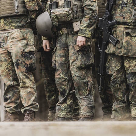 Mehrere Bundeswehrsoldaten stehen nebeneinander, es sind nur die Beine und Füße in Uniform zu sehen.
