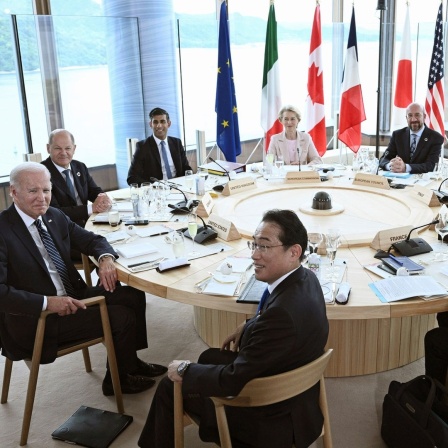 Die Teilnehmer des G7-Gipfels in Hiroshima sitzen während eines gemeinsamen Treffens an einem Tisch