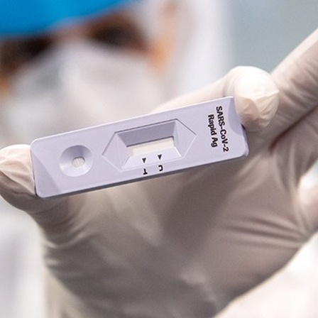 Eine Person in Schutzkleidung hält einen Antigen-Schnelltest in die Kamera; Foto: dpa (12.11.2020)