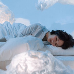 Eine Frau schläft auf Wolken