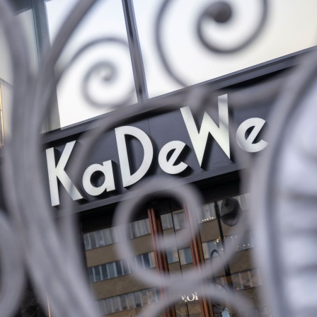 Durch ein Gitter vor einem Eingang des KaDeWe ist der Schriftzug des Kaufhauses zu sehen (Bild: picture alliance/dpa/Christophe Gateau)
