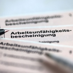 Stifte liegen auf den Arbeitsunfähigkeitsbescheinigungen für Arbeitnehmer im Falle einer Krankschreibung durch den Arzt