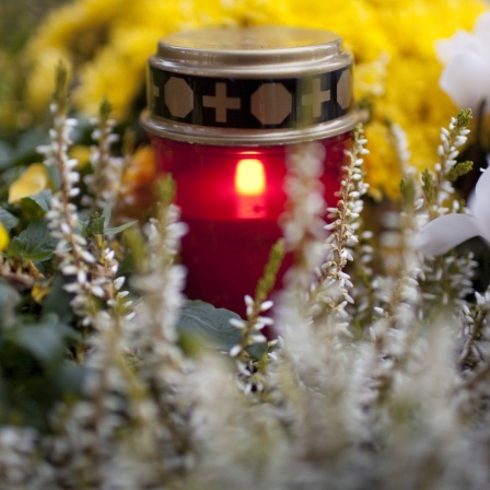 Brennendes Grablicht auf einem Friedhof