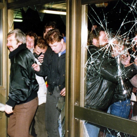 ARCHIV: Demonstranten stürmen am 15. Jan. 1990 die Zentrale der Staatssicherheit der DDR, Stasi, in Berlin (Bild: picture alliance/ASSOCIATED PRESS/Jockel Finck)