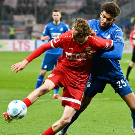 Nick Woltemade (l) und Hoffenheims Kevin Akpoguma kämpfen um den Ball.