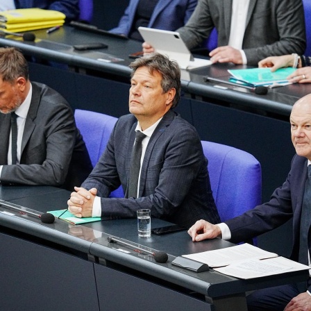 Bundeskanzler Olaf Scholz (SPD, r) sitzt im Bundestag neben Christian Lindner (FDP, l), Bundesminister der Finanzen, und Robert Habeck (Bündnis 90/Die Grünen, M), Bundesminister für Wirtschaft und Klimaschutz