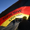 "Wir sind das Volk" steht auf der Fahne, die ein Teilnehmer auf einer Kundgebung der Thüringer AfD unter dem Motto "Zuerst unser Land! Leben muss bezahlbar sein" trägt.
