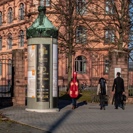 Eingang der Hochschule für Musik Karlsruhe mit Blick auf die Litfaßsäule und das Schloss Gottesaue