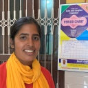 Eine Frau im indischen Bundesstaat Haryana steht vor einer Tabelle 