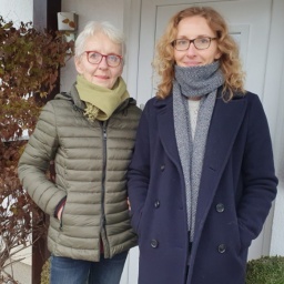 Gisela und Kerstin Kopp stehen nebeneinander vor einer Haustür.