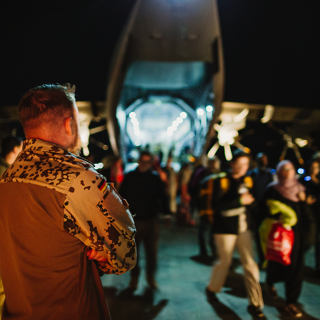 Menschen steigen bei einem Evakuierungseinsatz der Bundeswehr in Jordanien aus einem Transportflugzeug.