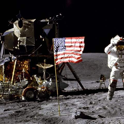 Der amerikanische Astronaut John W. Young neben der US-Fahne auf dem Mond, Apollo 16 Mission 1972