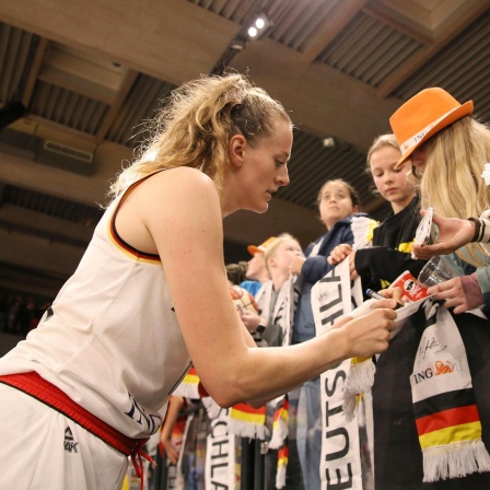 Die deutsche Basketballerin Marie Gülich verteilt Autogramme