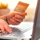 Eine Frau hält eine Kreditkarte beim Online-Shoppen