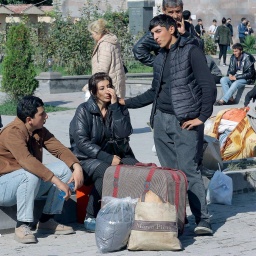Geflüchtete aus Bergkarabach Ende September 2023 ruhen sich nach ihrer Ankuft in der armenischen Stadt Goris auf Stufen aus.