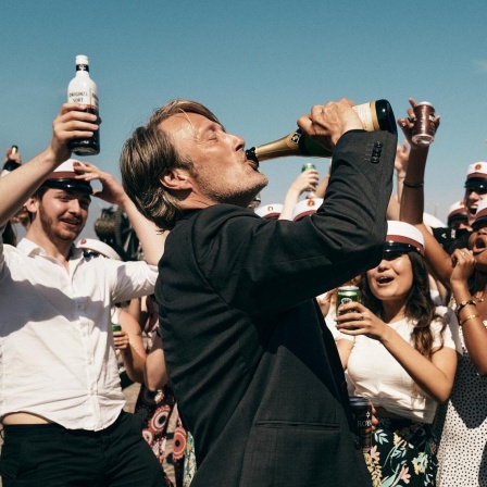 Der Schauspieler Mads Mikkelsen in einem Szenenfoto von Thomas Vinterbergs Film "Der Rausch". Mikkelsen trinkt aus einer Bierflasche.