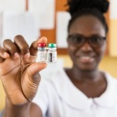 Eine Mitarbeiterin der Poliklinik in Capecoast hält zwei Döschen mit dem Impfstoff Mosquirix in die Kamera