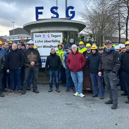 Mitarbeiter der FSG stehen vor dem Eingang der Firma.