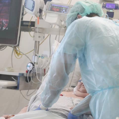 Ein Pfleger überwacht die Monitore bei einem Patienten auf einer Covid 19 Intensivstation. 
