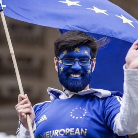 Pulse-of-Europe-Demonstrant in München, blau angemalt mit Europa-Fahne