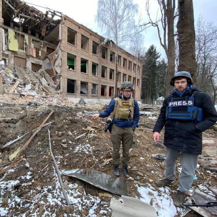 Zwei Journalisten stehen im ukrainischen Wassylkiw (bei Kiew) vor einem zerstörten Gebäude - eine Agenturaufnahme
      