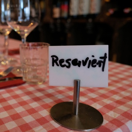 Symbolbild: Auf einem gedeckten Tisch in einem Restaurant steht ein Schild mit der Aufschrift "Reserviert"