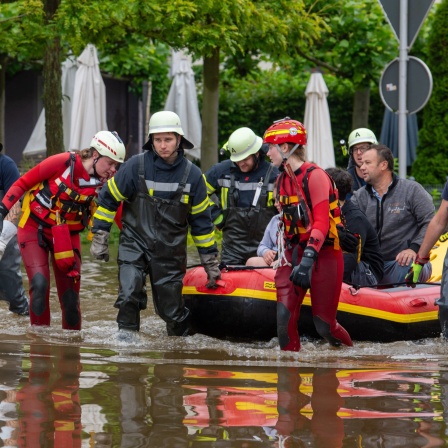 Mit einem Schlauchboot holen Feuerwehr und Wasserretter Anwohner aus ihren überfluteten Häusern. Nach dem Starkregen der letzten Tage kam es zu schweren Überschwemmungen im Süden von Baden-Württemberg und Bayern.