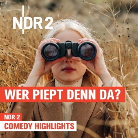 Eine Frau im beigefarbenen Mantel blickt durch ein Fernglas, umgeben von trockenem, wildem Gras in herbstlicher Landschaft.