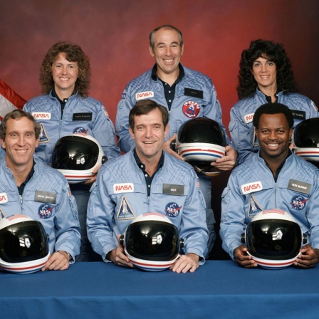 Die sieben Besatzungmitglieder der verunglückten Raumfähre Challenger posieren für ein Gruppenfoto mit Helmen und in Raumanzügen.