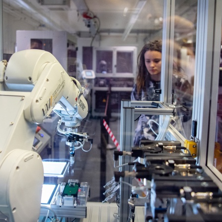 Schüler schauen sich in einem Betrieb eine Maschine an