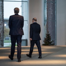 Bundeskanzler Olaf Scholz und Bundespressesprecher Stefan Hebestreit gehen einen Gang entlang. Man sieht sie von hinten.