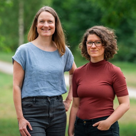 Zwei weiße Frauen mittleren Alters stehen nebeneinander