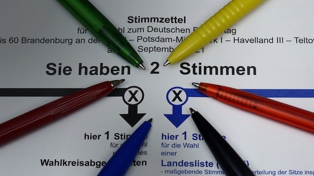 Auf Stimmzettel zur Bundestagswahl liegen Kugelschreiber in den Parteifarben (Bild: picture alliance / ZB | Z6944 Sascha Steinach