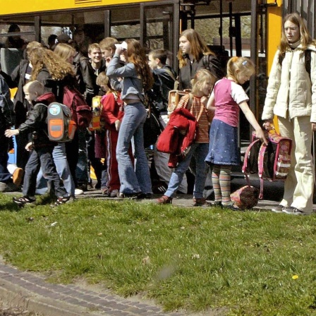 Schüler entsteigen einem Schulbus