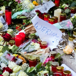 «Warum» steht inmitten von Blumen und Kerzen vor der Johanniskirche auf einem Papier.