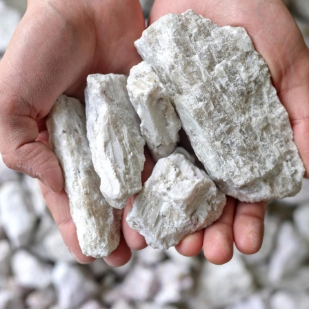 Hände halten ein weißes Gestein, das Lithium enthält(Symbolbild)