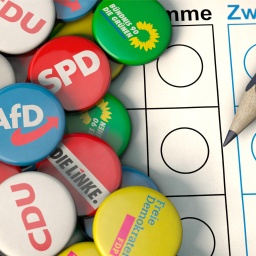 Symbolbild mit verschiedenen Parteien und einem Stimmzettel