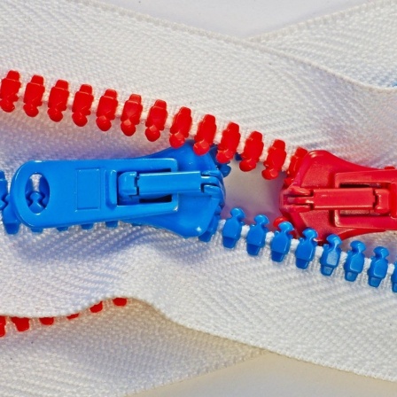 Ein roter und ein blauer Reißverschluss greifen ineinander.