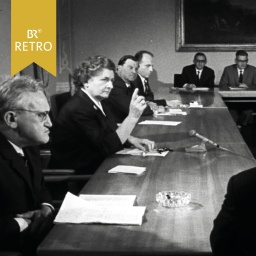 Ein Frau umgeben von Männern hebt in einer politischen Sitzung die Hand | Bild: BR Archiv