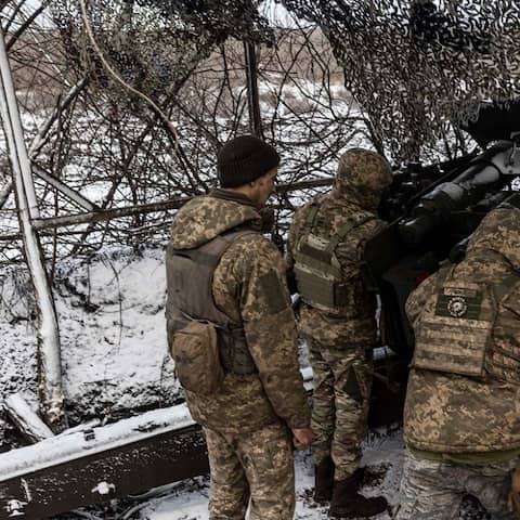 Ukrainische Soldaten bereiten eine Waffe vor, es liegt Schnee.