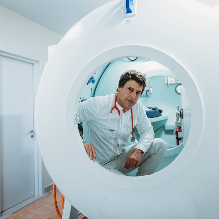 Mediziner Oliver Opatz in seinem Forschungslabor, er schaut in die Kamera. Er beschäftigt sich mit Krankheiten, die im Weltall bei Astronaut:innen auftreten: G-Masern, Puffy Face oder Space Adaptation Back Pain. Im All reagiert der Körper anders, als auf der Erde.