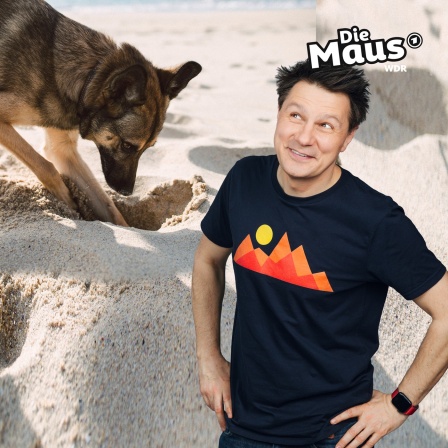 André neben buddelndem Hund im Sand