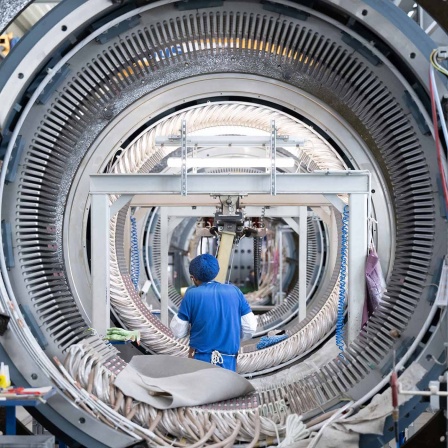 Ein Mitarbeiter der Partzsch Unternehmensgruppe im sächsischen Döbeln arbeitet in einer Fertigungshalle an einem Stator für Windkraftanlagen.