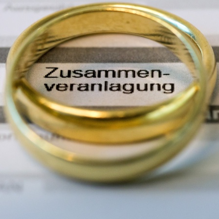 Goldene Eheringe liegen 2013 auf Formularen für die Steuererklärung.