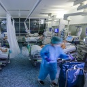 Eine Intensivpflegerin versorgt einen Covid-19-Patienten auf einer Intensivstation der Leipziger Uniklinik in einem Zimmer, in dem noch drei weitere Corona-Patienten liegen.
